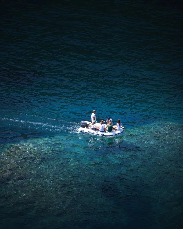 Guests seated aboard a covered pontoon boat on the water